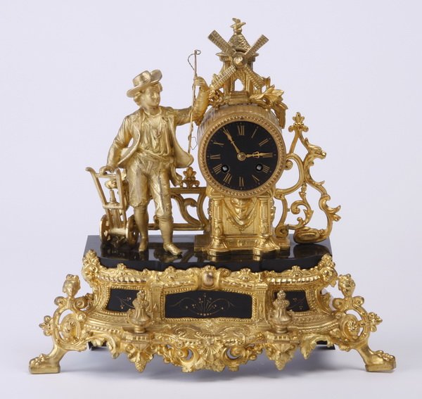 Dutch gilt metal and marble mantel clock: Late 19th century Dutch gilt metal and Belgian black marble figural clock, with a boy in period dress flanking a foliate adorned windmill surmounting an ebony porcelain dial, all raised on a shaped ba