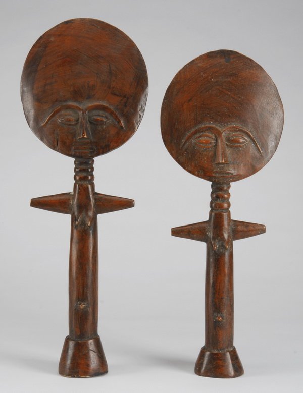 (2) Ashanti dolls, Ghana: Group of two Ashanti dolls or "akuaba", Ghana, worn by women for fertility and to ensure a healthy pregnancy, of carved and stained wood with a circular face, over the tapering cylindrical body with o