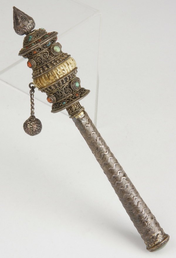 Tibetan silvered metal prayer wheel: Tibetan silvered metal prayer wheel or "mani chho-knor", Nepal, comprised of silvered metal encrusted with semi-precious stones, and containing rolls of written prayers, 8.5"l x 1.5"w.