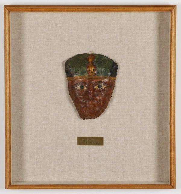 Roman period Egyptian mummy mask: Egyptian mummy mask, painted gesso over linen, with a label dating it to 1st century Roman period, 7.5"h x 6"w, mounted in a custom linen-lined shadow box 21.5"h x 19.5"w x 3"d.