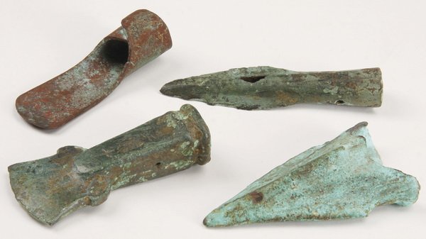Assorted ancient copper and bronze blades: Group of assorted ancient copper and bronze blades, includes: (1) Egyptian hoe, 1200 B.C., (1) Roman spear point, 300 B.C., (1) West Asian axe head, 1000 B.C., and (1) Greek celt, 700 B.C.