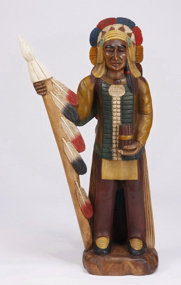 Hand carved and decorated cigar store Indian: 20th century hand carved wood and polychrome decorated cigar store Indian, with a spear and full length carved feathered headdress, 40.5"h x 23"w x 10"d.