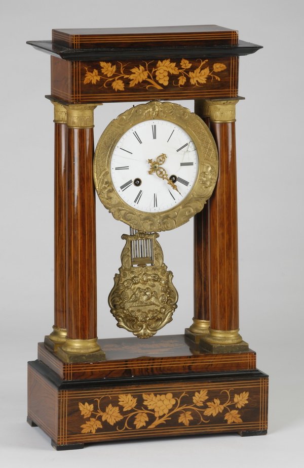 19th c. French inlaid portico clock: Late 19th French marquetry inlaid walnut portico clock, the corniced top surmounting a central dial encircled by a moon and face decorated bezel, above a large pendulum with fruit, bird and scrolling 