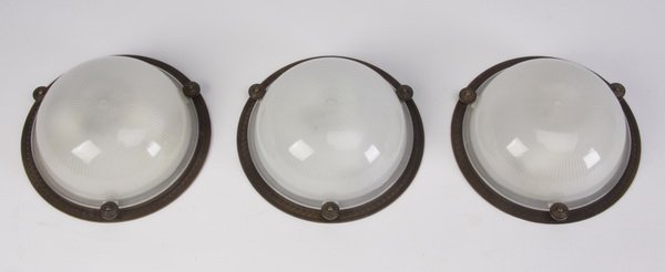 (3) Glass and bronze ceiling mounted lights: Set of three late 20th century ceiling mounted light fixtures, the ribbed glass shade with bronze framing, each 3.75"h x 9" diameter.