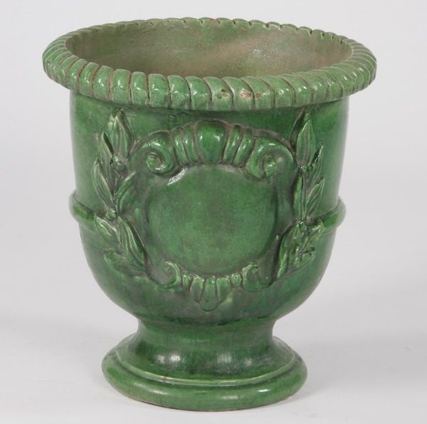 French glazed earthenware jardiniere: French green glazed earthenware jardiniere of urn-form with a gadrooned rim and a large central foliate design, 22"h x 20.5" diameter.