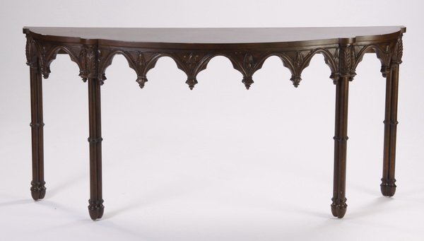 Gothic inspired carved demilune table: 20th century Gothic inspired carved demilune table, the shaped top over an apron of trefoil heads interspersed with stylized floriate designs, the four sets of legs in the form of trefoils surmounted 