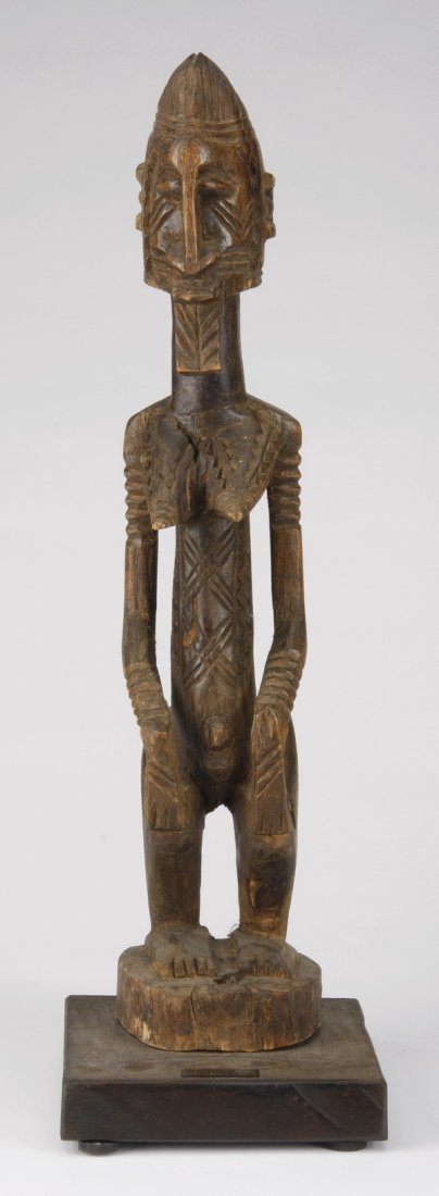 Lobi hermaphroditic figure, Mali: Lobi hermaphroditic figure or "nommo", Dogon, Mali, representing a mythological ancestral spirit once placed in a shrine, the carved wood form with amphibian features and geometric details, 19"h x 4"w