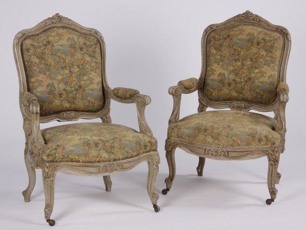 (2) French paint decorated armchairs: Pair of mid 20th century French Louis XV style carved and paint decorated bergeres, with a serpentine frame adorned with acanthus leaves, the cartouche-form back, seat and arms upholstered in a green,