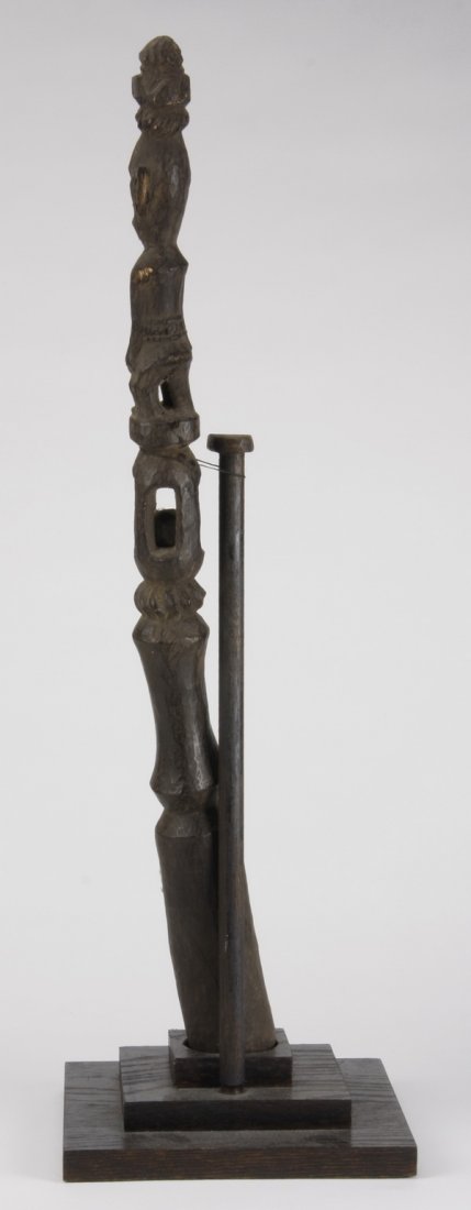 Minangkabau figural sculpture, Indonesia: Minangkabau figural sculpture, Batak Sumatra, Indonesia, the carved wood of slender stylistic form, enclosing a ball, overall size including stand 27"h x 8.5"w x 8.5"d.