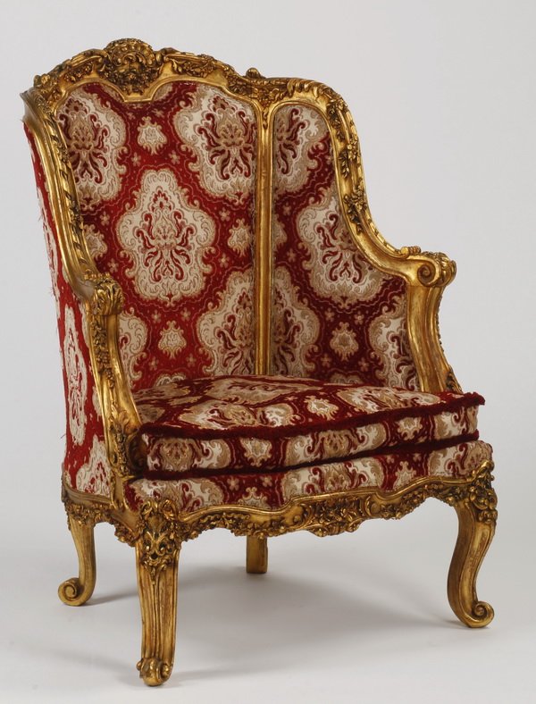 Louis XV style giltwood bergere: Late 19th or early 20th century Louis XV style giltwood bergere, the carved giltwood frame with a C-scroll crest issuing floral garlands, upholstered in red and white cut-velvet accented with gilt thr