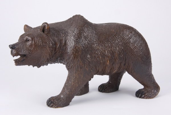 Black Forest carved bear: Early 20th century Black Forest carved wood model of a strolling bear, with glass eyes, 5.5"h x 13.5"l x 2.5"w.