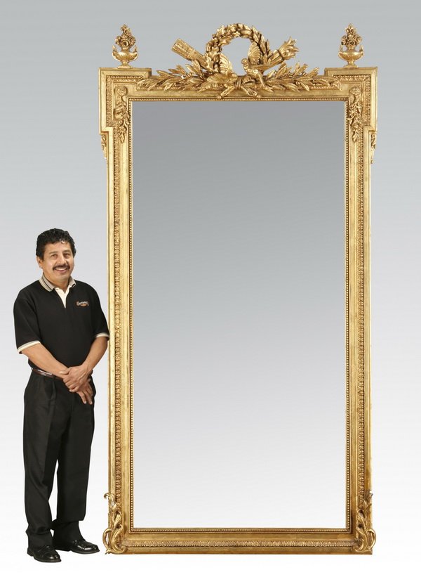 19th c. French giltwood pier mirror: Monumental 19th century French Louis XVI style carved giltwood and gesso pier mirror, with a central foliate wreath encircling a pair of lovebirds flanked by flowering urns, all surmounting a rectangu