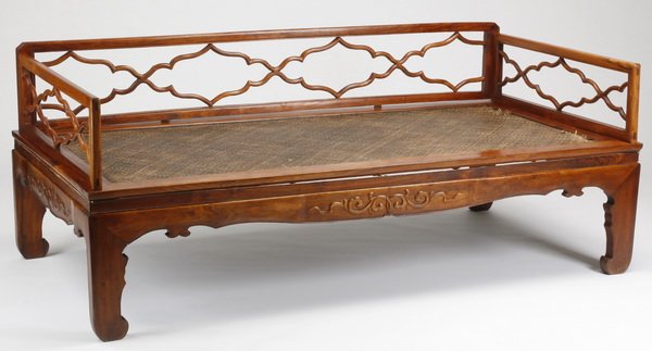 Early 20th c.. Chinese huanghuali daybed: Early 20th century Chinese carved huanghuali daybed, the openwork rails comprised of repeating cartouches, surrounding the rectangular frame enclosing the cane seat, over a shaped and waisted skirt ad