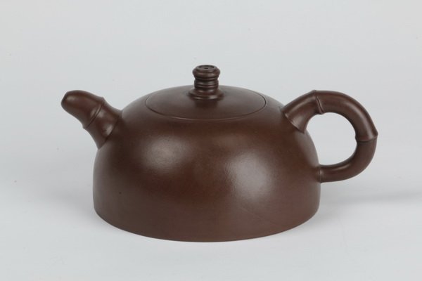 Chinese zisha clay teapot, marked: Early 20th century Chinese Yizhing stoneware teapot, the zisha clay of globular form with the handle and spout rendered to simulate bamboo, the base with seal mark, and further marks to the lid and ha