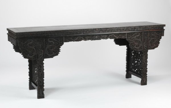 Oversized Chinese zitan altar table, 19th c.: Oversized late 19th or early 20th century Chinese zitan altar table, ornately carved with dragons pursuing flaming pearls against a densely filled ground of cloud forms, the rectangular top surmountin