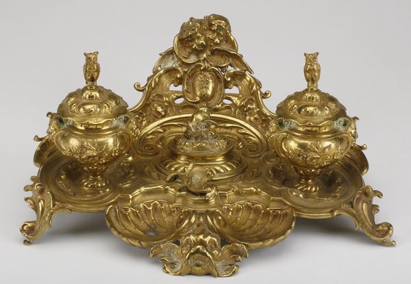 19th c. Continental gilt bronze encrier: Mid to late 19th century Continental Revival style gilt bronze encrier, the foliate base having two lidded inkwells with owl finials, flanking an additional container above a pair of shell trays, all 