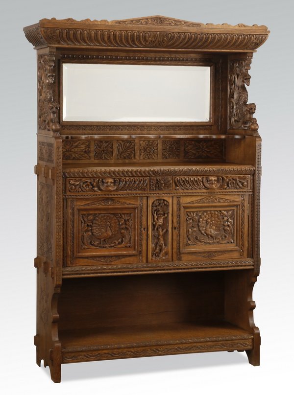 Early 20th c. carved oak cabinet: Early 20th century carved oak cabinet, with a gadrooned cornice over a beveled glass mirror and serpentine shelf flanked by animal form corbels, all over two animal mask drawers and double doors with 