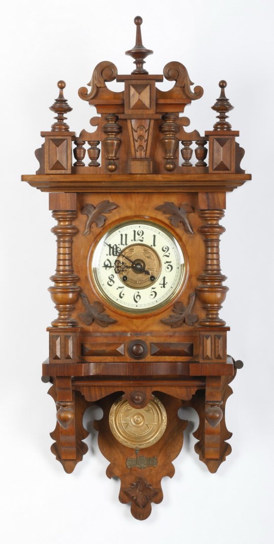 German carved walnut regulator clock, 19th c.: 19th century German carved walnut regulator clock, the elaborate crest and finials above a circular dial flanked by two exaggerated pilasters, all above a gilt metal pendulum, 40"h x 16.75"w x 8"d.