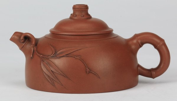Yixing teapot, in the style of Zhou Guizhen: Yixing teapot, in the style of Zhou Guizhen, with a bamboo-form segmented handle, and having a moulded sprig of bamboo applied to one side of the body and spout, the other side undecorated, the base f
