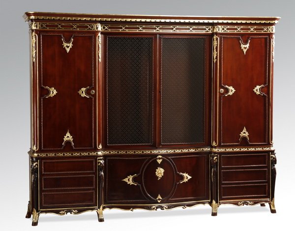Mahogany cabinet with gilt accents: Mahogany cabinet with gilt accents, the shaped rectangular top surmounting central double glass doors with metal lattice over the glass, flanked by two doors, above a serpentine central compartment op