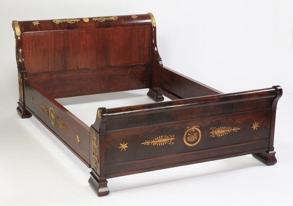 Empire mahogany & gilt bronze bedstead: Empire parcel gilt and mahogany bedstead, having a scrolled headboard centering gilt bronze rosettes flanked by flourishes and figural swan terminals, the dore' bronze mounts continuing down the sides