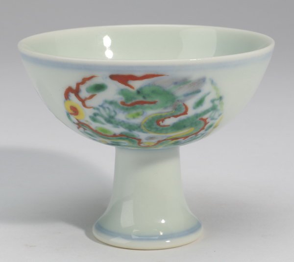 Chinese footed wine cup, Yongzheng mark: Chinese wucai enamel porcelain footed wine cup depicting a dragon chasing the flaming pearl amidst flames, the underside with a blue underglaze six-character Yongzheng mark, 2.5"h x 3.25"w.
