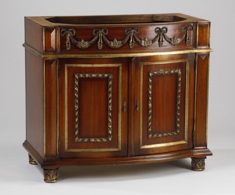 Carved, parcel gilt cabinet / bathroom vanity: Neoclassical style carved and parcel gilt mahogany cabinet, the frieze with foliate swags and ribbons over two paneled doors, with ribbon and stick borders, the whole rising on four acanthus carved fe