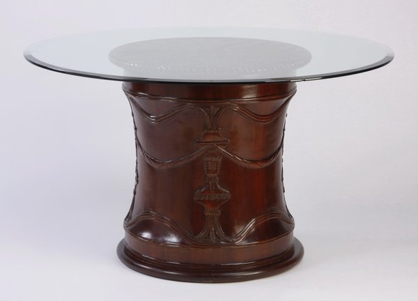 Glass top table with carved mahogany base: Beveled glass top table, the cylindrical mahogany base relief carved with urns issuing fronds joined by rope swags, the base top with symmetrical, carved fronds all encircled in a rope trim, 31"h x 54