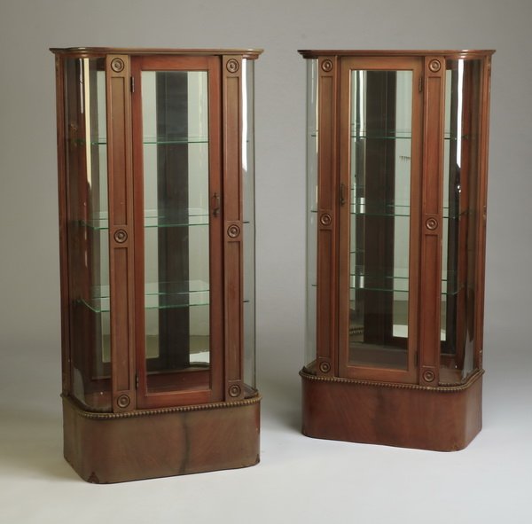 (2) Early 20th c. American vitrines: Pair of early 20th century American demilune shaped vitrines with original curved glass side panels, and decorative egg and dart molding, 60.75"h x 28.25"w x 15"d.