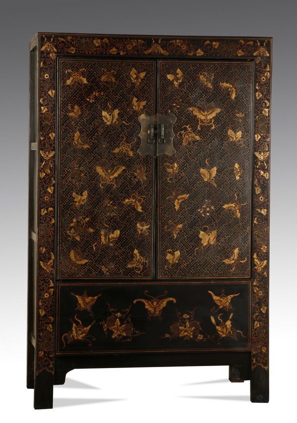 Asian inspired armoire w/gilt butterfly design: Asian inspired armoire, having an allover gilt design of butterflies and flowers with fretwork on a black ground, the front having two solid panel doors with a bronze latch opening to a hanging rod, t