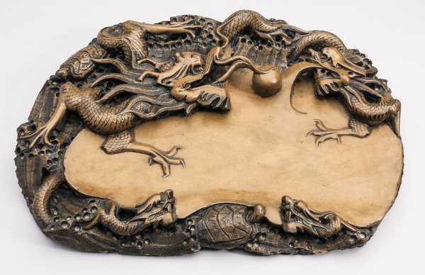 Chinese ink stone with confronting dragons, 15"w: Chinese ink stone, depicting confronting dragons chasing a pearl of wisdom, surrounded by turtles and smaller dragon heads, 11.5"h x 15"w x 2.25"d.