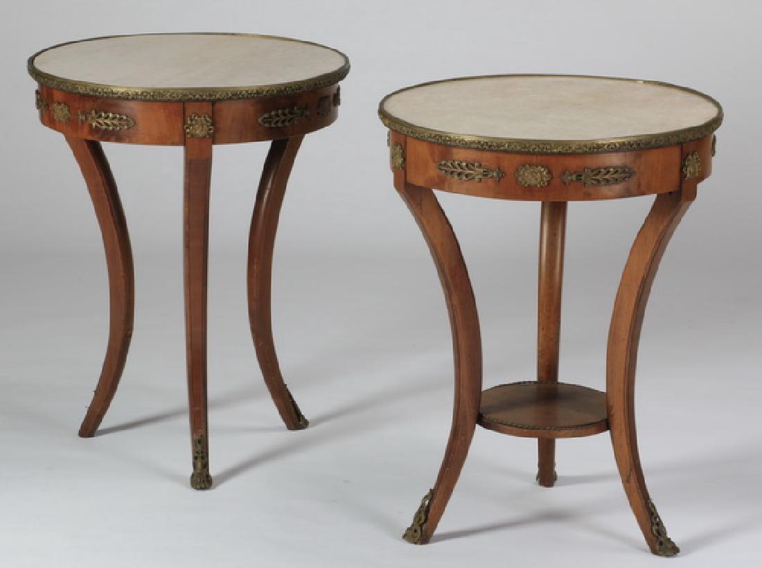 (2) Louis XV style marble top gueridons: Pair of 20th century French Louis XV style bronze mounted marble top gueridons, the circular top surmounting a leaf and cameo decorated apron, raised on three splayed legs, one with an undertier, 26"h