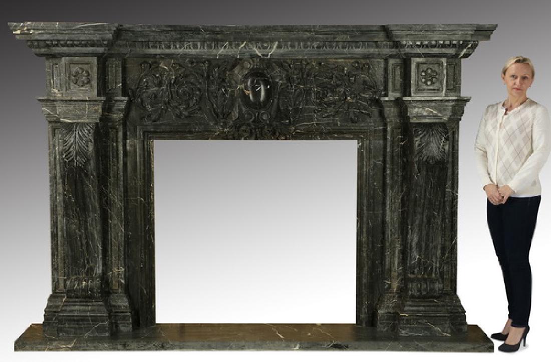Carved black marble fireplace mantel, 97"w.: Large and impressive carved black marble fireplace mantel in the Neoclassical taste, the stepped top above the carved frieze centering a shield cartouche flanked by foliate swags, the whole supported 