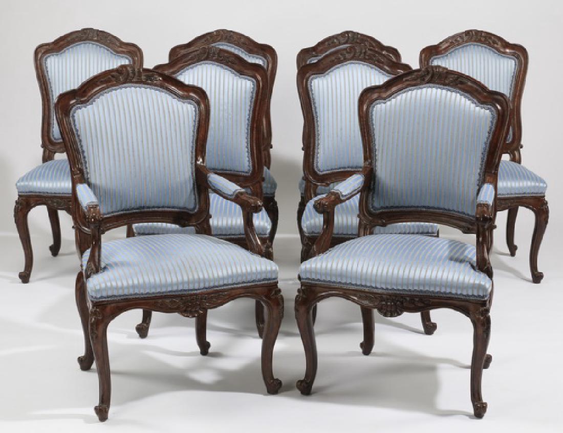 (8) French Provincial upholstered chairs: Set of eight French Provincial style dining chairs, comprising two armchairs and six side chairs, each carved with a floral and C-scroll crest, the back and seat upholstered in light blue striped sati