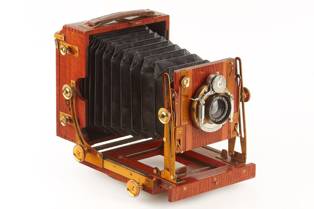 The Sanderson Tropical Field Camera: 9x12cm, polished mahogany wooden body with brass fittings, black bellows, Aldis Brothers Series II No.2 no.575 in working pneumatic shutter, cap, ground glass adapter, one double plate film holder, ca