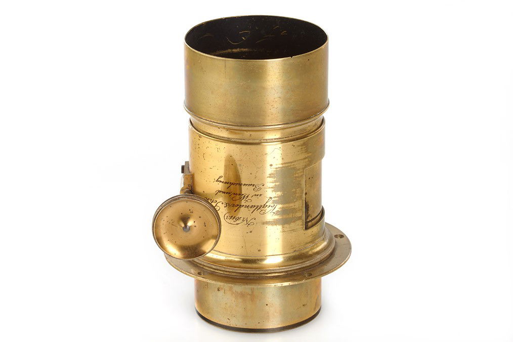 Voigtländer Petzval Lens: approx. 25cm focal length, very good optics, rack and pinion focusing, barrel engraved 'Voigtländer & Sohn in Wien und Braunschweig', lens diameter c.7cm, total height incl. hood 18cm, for waterhouse