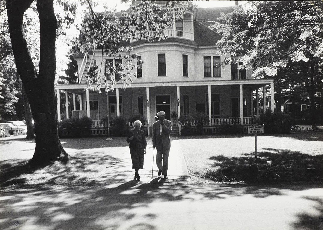 Robert Frank, Senior couple: Robert Frank (* 1924), Senior couple in front of Alumni Hall, Chautauqua, New York 1953. 6.6 x 9.5 inches, Photographer's »Life Photo by Robert Frank« stamp on the reverse, »Life« reproduction sta
