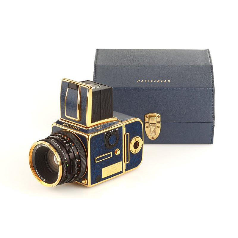 Hasselblad 503 CX Golden Blue, SN: 01EV10122, 199: gold-edition with blue leather (special number 114) with magazine no.03EV10136, CF Planar 2.8/80mm T* no.7208106, cap, strap, leather presentation box, golden UV filter in keeper