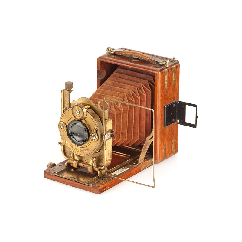 Ihagee Neugold, no. 78487: 6.5x9cm tropical folding plate camera, polished teak wooden body, brass fittings, brown leather bellows, Goerz Dogmar 4.5/10cm no.591797 in gilt Compur shutter, rare camera with original screen adapte