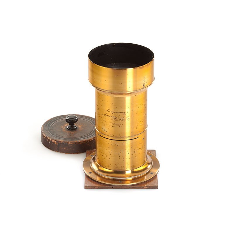 C. W. Häring Braunschweig Petzval Lens, no. 450: very rare lens, approx. 50cm focal length, c.10.5cm lens diameter, for waterhouse stops, hood, front shutter cap, total height c.30.5cm, with mounting ring on wooden lens board (c.18x18.5cm) - This sm