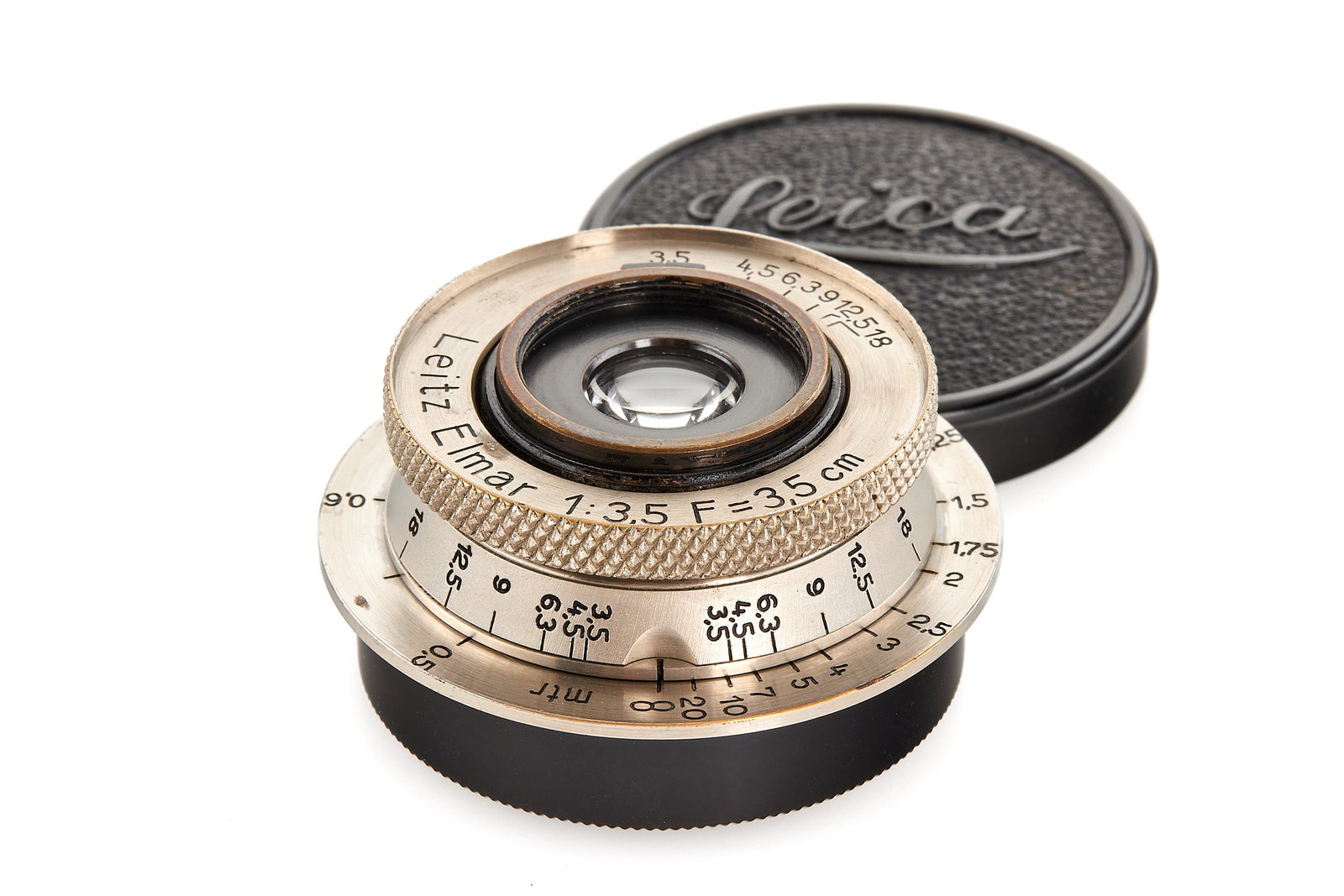 Elmar 3.5/3.5cm nickel *: Beautiful very early unnumbered EKURZ in almost mint condition, optics showing a few cleaning marks, in meter scale, note the absence of infinity lock, with both caps.