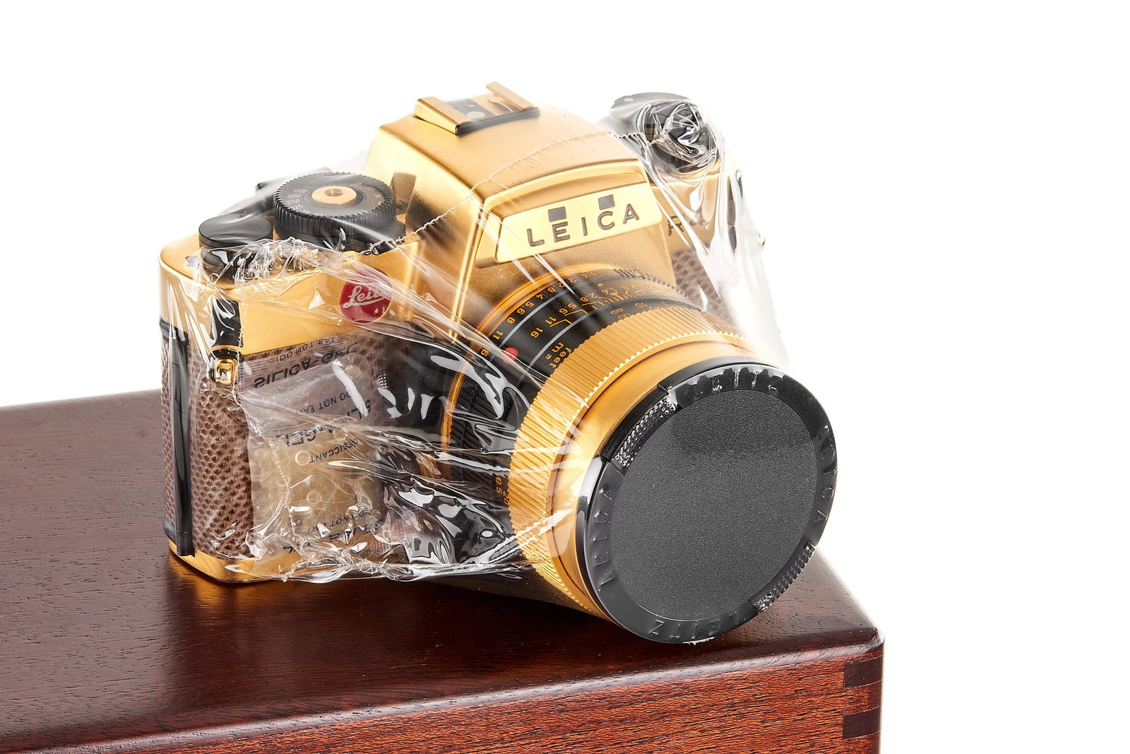 Leica R4 Gold *: Limited edition gold plated R4 (only 1000 pieces produced) with special covering, in unused condition, still sealed in plastic, body number 1652233, with matching gold plated Summilux-R 1.4/50mm