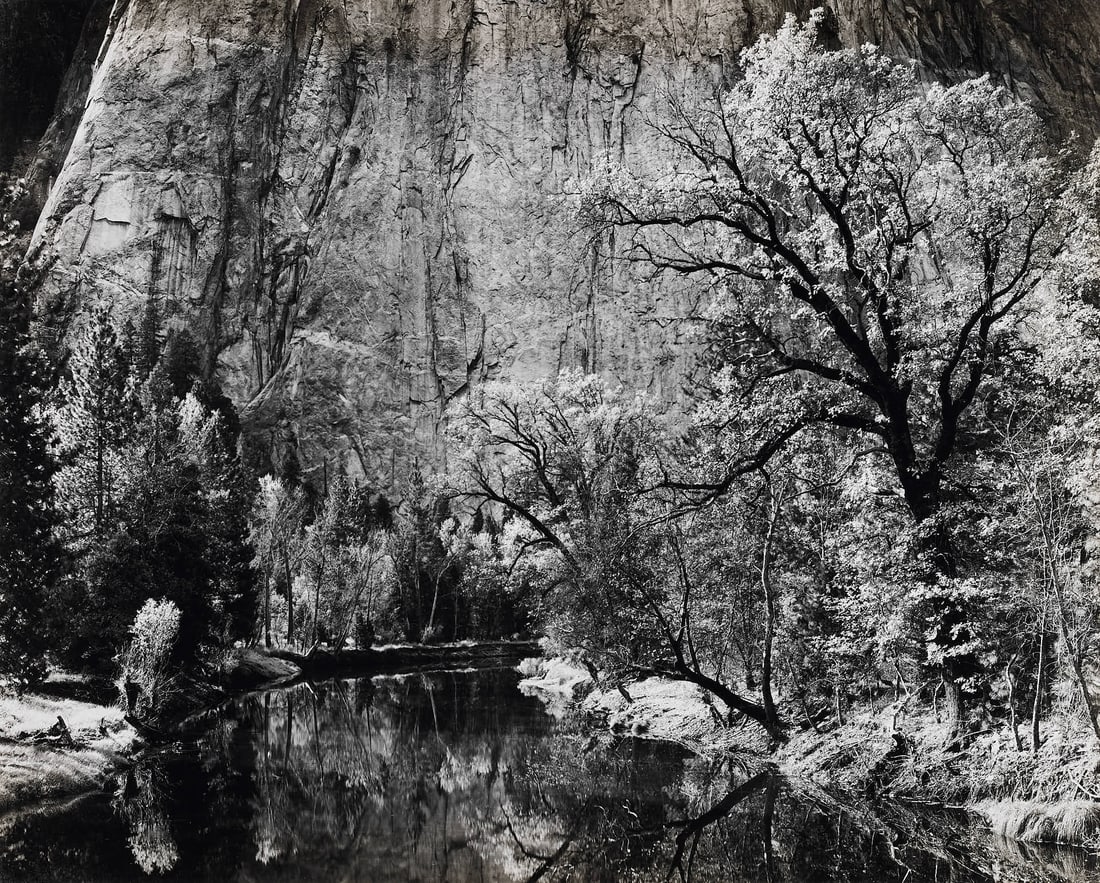 ANSEL ADAMS (1902–1984) - Merced River, Cliffs of the Cathedral Rock, California 1939: Gelatin silver print, printed 1959, mounted on original cardboard 18,6 x 22,9 cm (7.3 x 9 in) Plate 2 from `Portfolio Three: Yosemite Valley`( San Francisco 1960, Edition 260) Signed by the