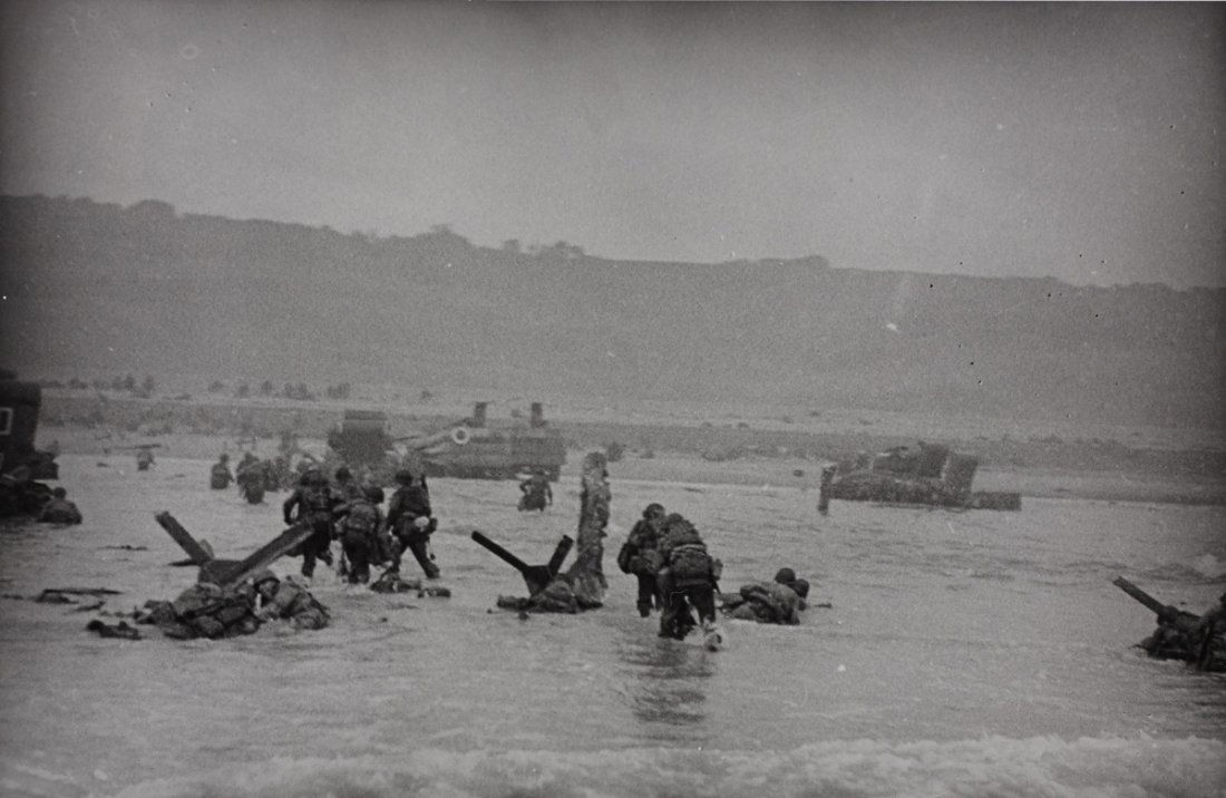 ROBERT CAPA (1913 - 1954): Omaha Beach, June 6th 1944, Gelatin silver print, printed 1984 22 x 34 cm (8.7 x 13.4 in) Photographer's agency stamp, date stamp (most likely refering to the print date) and various notations in ink
