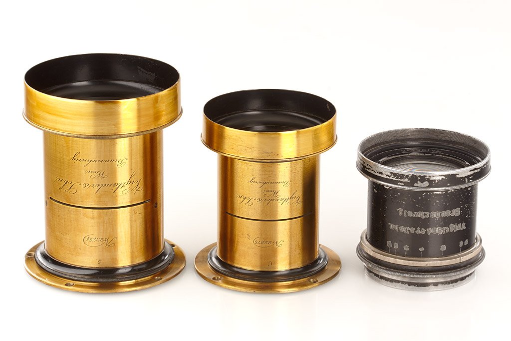Voigtländer Brass Lenses: (1) R.R. Aplanat engraved 'C.' no.22274, approx. 52cm focal length, lens diameter 6.5cm, goo lenses, mounting ring, total height incl. hood 12cm, (2) R.R. Aplanat engraved '5' no.23751, approx. 70cm f