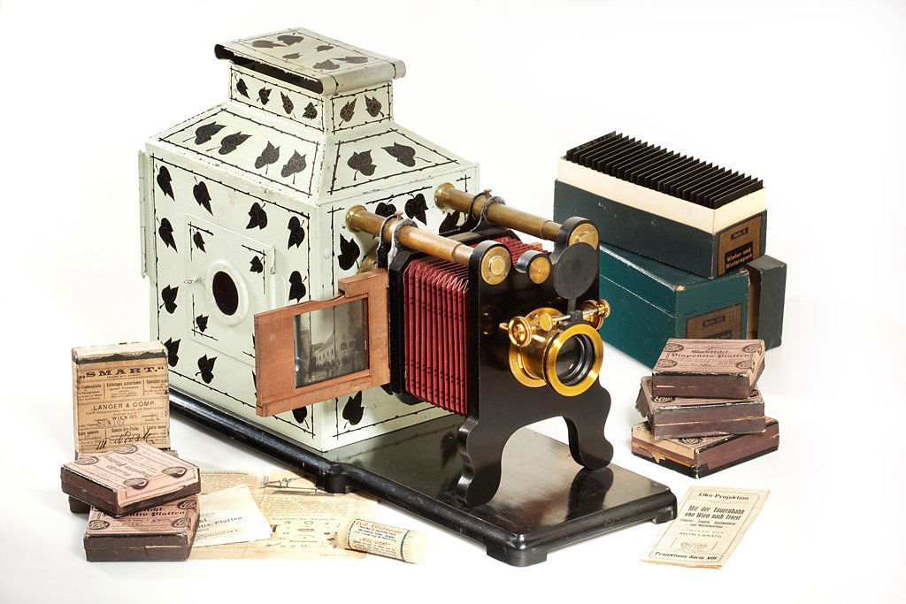 Elko Slide Projector *: beautiful Austrian large format slide projector mounted on an ebonized wooden board. The optical unit can be adjusted by sliding the wooden lens holder along two horizontally mounted brass tubes, in a