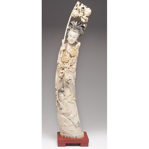 Asian sculpture, large intricately carved: Asian sculpture, large intricately carved tusk depicting a goddess and a man with a lute, incised characters on foot and base, supported by a wooden stand with cinnabar color, overall: 6.5"w x 28.5"h