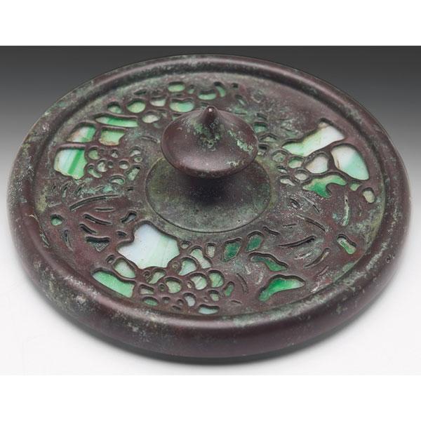 Tiffany Studios paperweight, round form, bronze, g: Tiffany Studios paperweight, round form, bronze in the grapevine pattern over green and white glass, signed Tiffany Studios, New York, 3.75"w x 1.5"h, crack to glass