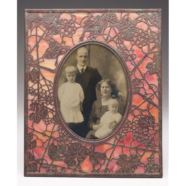 Tiffany Studios frame, bronze in the grapevine pat: Tiffany Studios frame, bronze in the grapevine pattern over red and yellow glass, signed Tiffany Studios, New York, 7.75"w x 9.75"h, several cracks to one glass panel