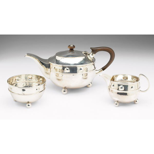 A.E. Jones tea set, England, 1922, #68,: A.E. Jones tea set, England, 1922, #68, teapot: 9.5"w x 4.5"h; creamer: 5"w x 3"h; sugar: 3.75"w x 2.25"h, all in hammered sterling silver, teapot with wooden handle and finial, all marked